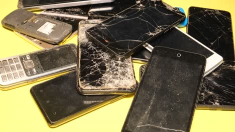 pile of broken mobile phones