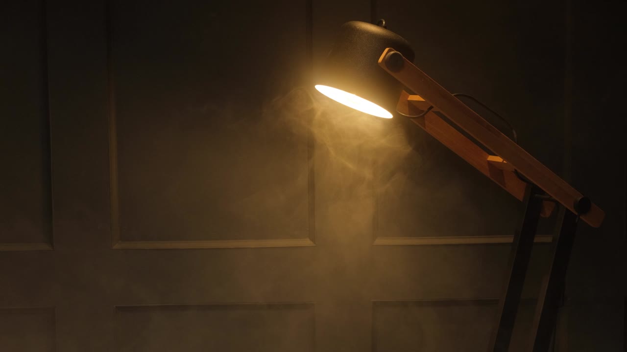 벽을 배경으로 실내에서 빛나는 장식 램프. 전구에서 분산된 연기와 따뜻한 빛