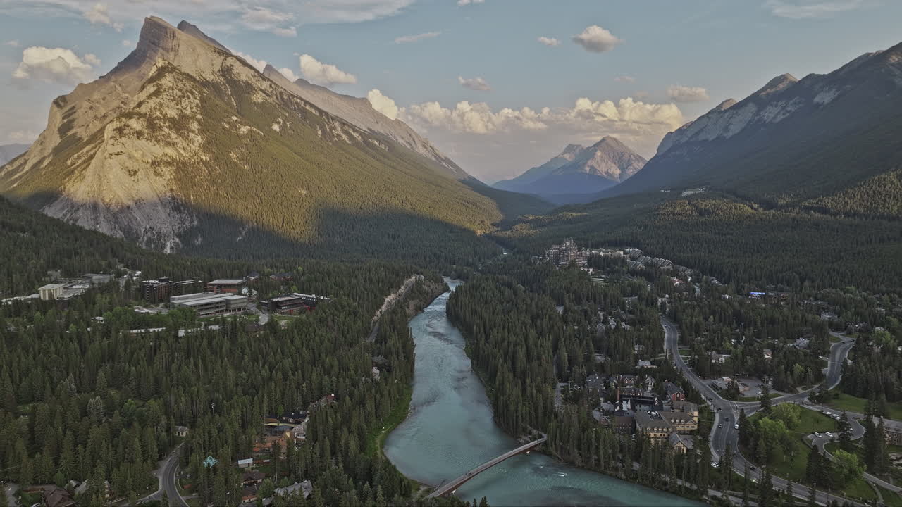 banff ab canada aerial v2 drone captura la ciudad ribereña y las casas residenciales, el agua turquesa prístina del río bow, los valles boscosos y las montañas al atardecer - filmado con mavic 3 pro cine - julio 2023