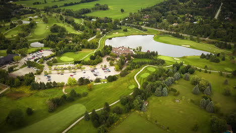 Schöne-Luftaufnahme-über-Einen-Großen-Golfplatz,-Umgeben-Von-üppigen-Feldern