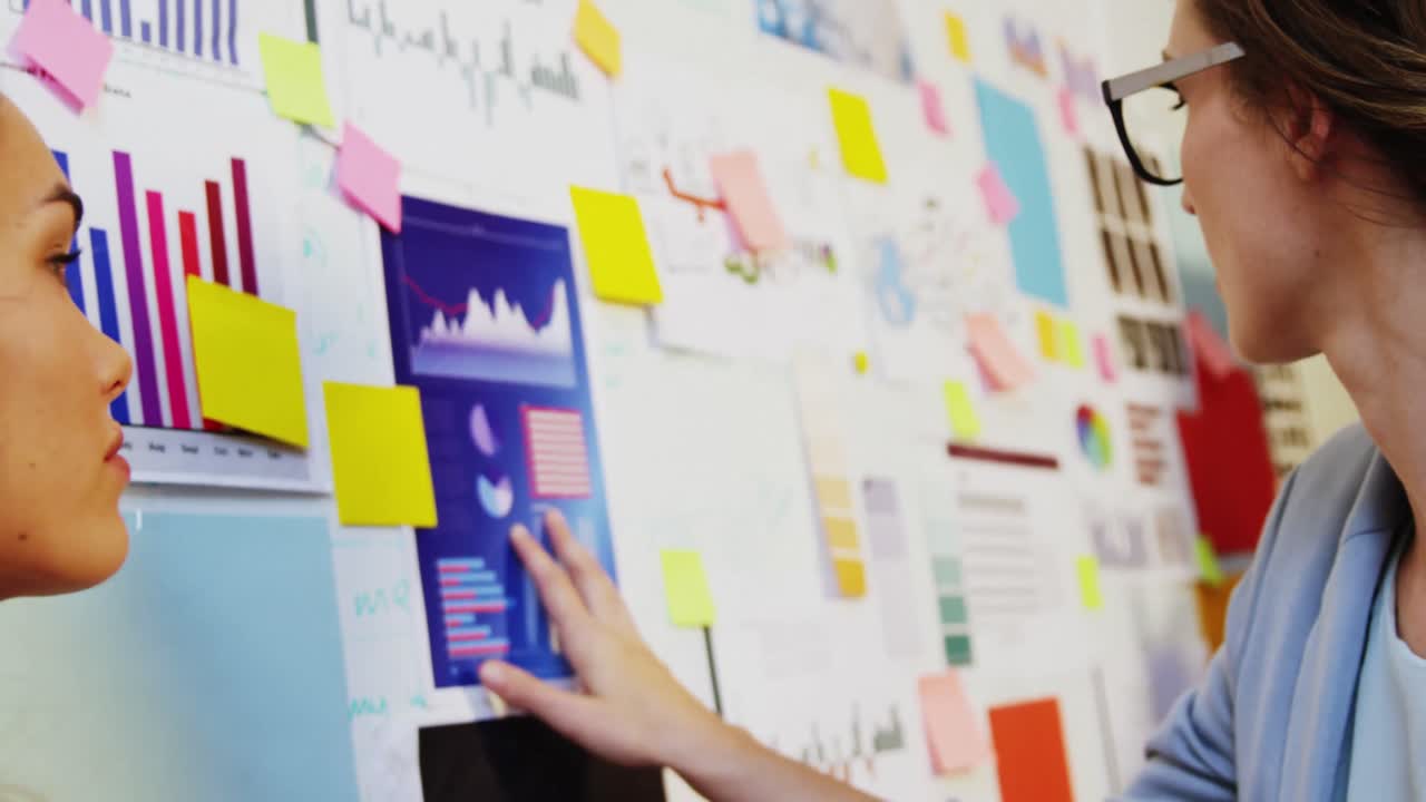 mujer de negocios mirando notas adhesivas en la pizarra