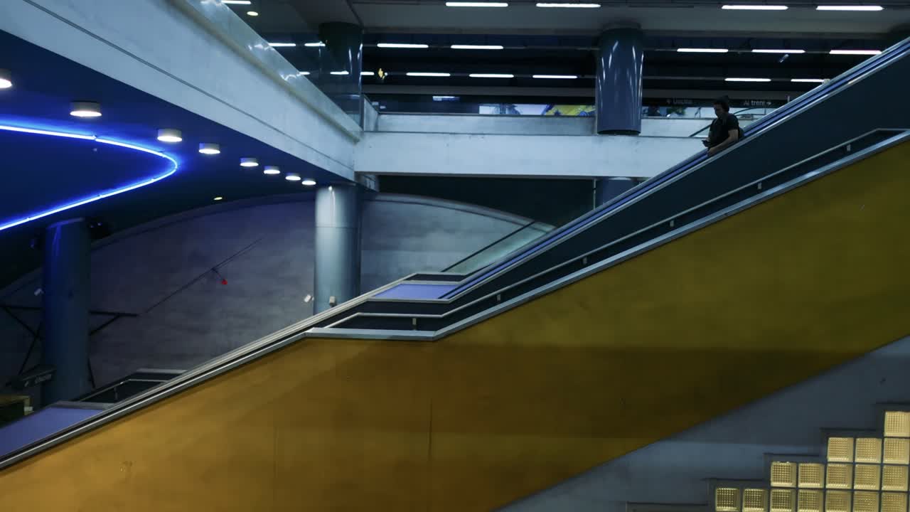 Person kører op ad rulletrappe på en moderne togstation
