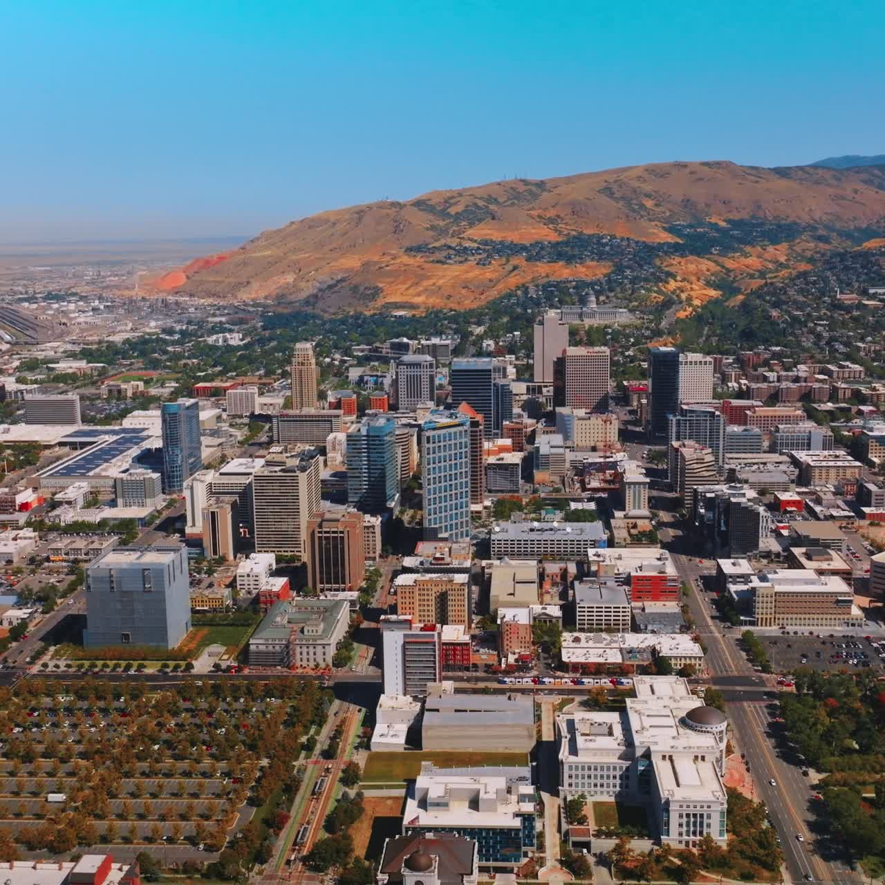 Salt Lake City downtown at sunny daytime. Amazing city scenery at the backdrop of beautiful mountains. Top view