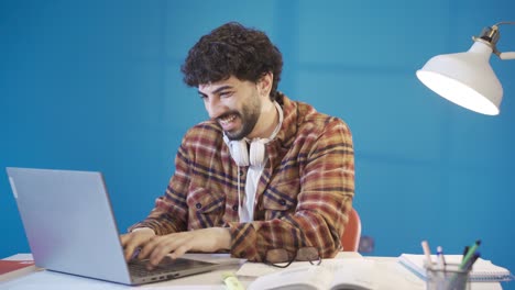 successful male student looking at laptop screen rejoicing.