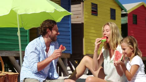 Family-eating-watermelon-at-beach