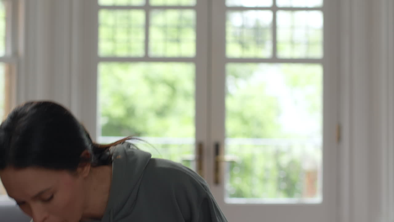 집에서 편안하게 간식을 먹고 소파에 앉아 노트북에서 일하기 전에 생활비 위기에 대해 걱정하는 불안한 여성