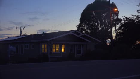 a 1940's style house with the lights on at night 1