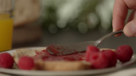 extendiendo mermelada vegana de delicioso sabor durante la comida del desayuno zoom en primer plano