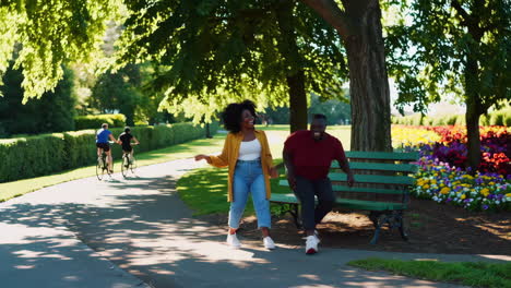 two people share a joyful moment on a park bench