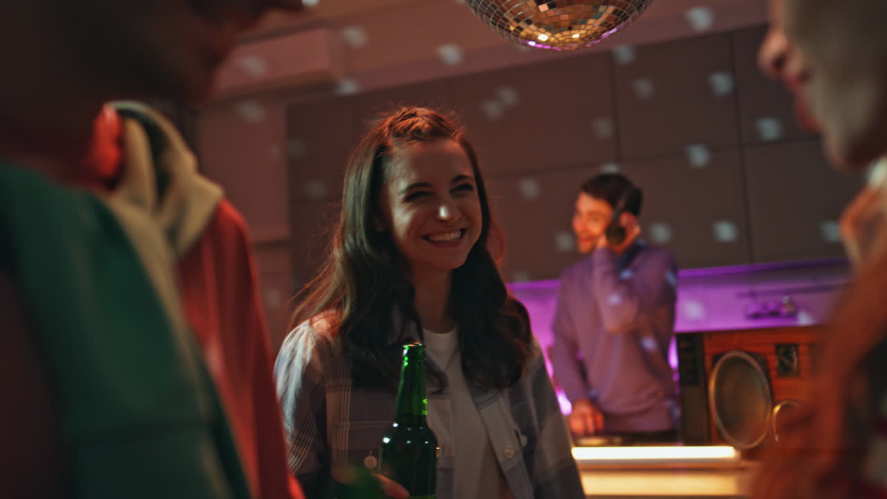 Junge Hipster genießen Disco-Party in der Wohnung, beleuchtet von Neon-Kugellicht.