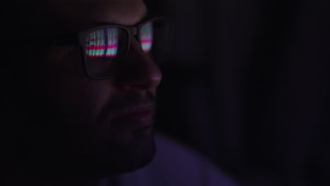 primer plano de las gafas hombre. inversor viendo el cambio de la bolsa de valores en la pantalla del portátil. comerciante superior mira gráficos corriendo análisis de datos para hacer la mejor venta. lleno de pantallas y estadísticas