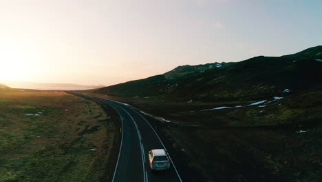 kleifarvatn aerial view following vehicle travelling long road towards hazy sunset hills