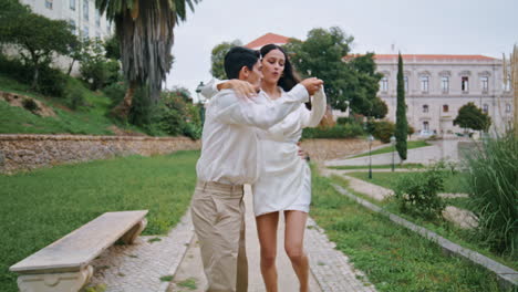 passionate lovers dancing park alley. energetic pair moving salsa choreography