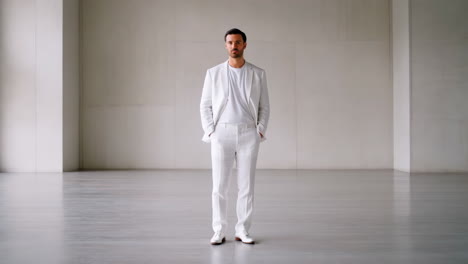 man in white suit in a minimalist room