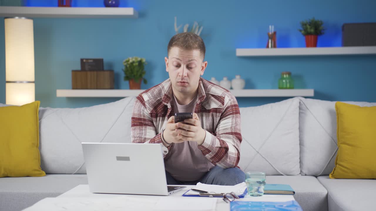 Man working from home enjoys mobile apps on phone.