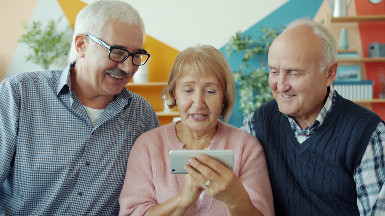 Amici anziani che interagiscono con uno smartphone