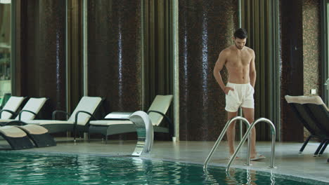 Entspannter-Mann,-Der-Am-Pool-Eines-Luxushotels-Spaziert.-Mann-Schwimmt-Allein-Im-Pool.