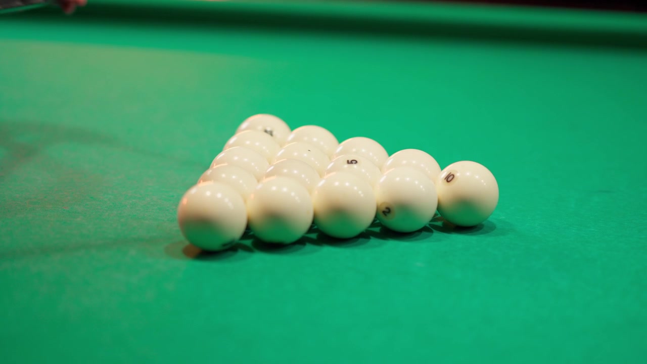 Close-up of Hands Arranging Billiard Balls on a Green Table