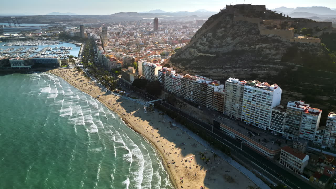 Aerial drone view of the Santa Barbara Castle on the coast of Alicante, Spain with the city and the sea in daylight