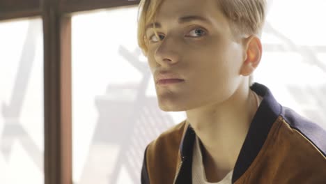 young man sitting near window in old room