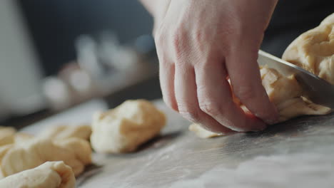 las manos del panadero cortando pedazos de masa