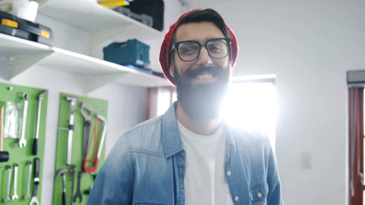 retrato de un mecánico de pie con una herramienta de trabajo en un taller