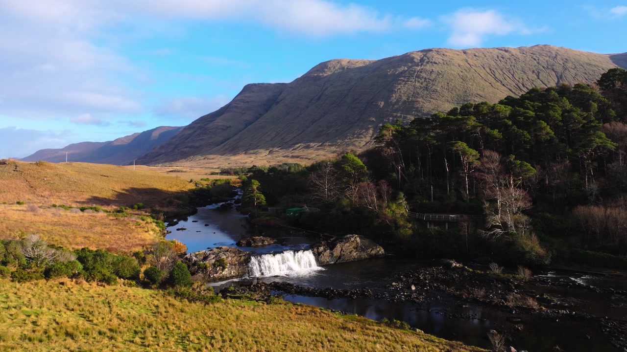 4K Aerial view of Aasleagh Falls highlighting a small waterfall along a river in a remote natural setting. Captures the movement of water and surround._07