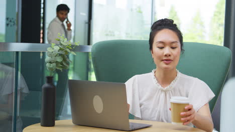 Mujer-De-Negocios-Utilizando-Un-Ordenador-Portátil-Trabajando-En-La-Mesa-En-La-Zona-De-Descanso-Del-Edificio-De-Oficinas