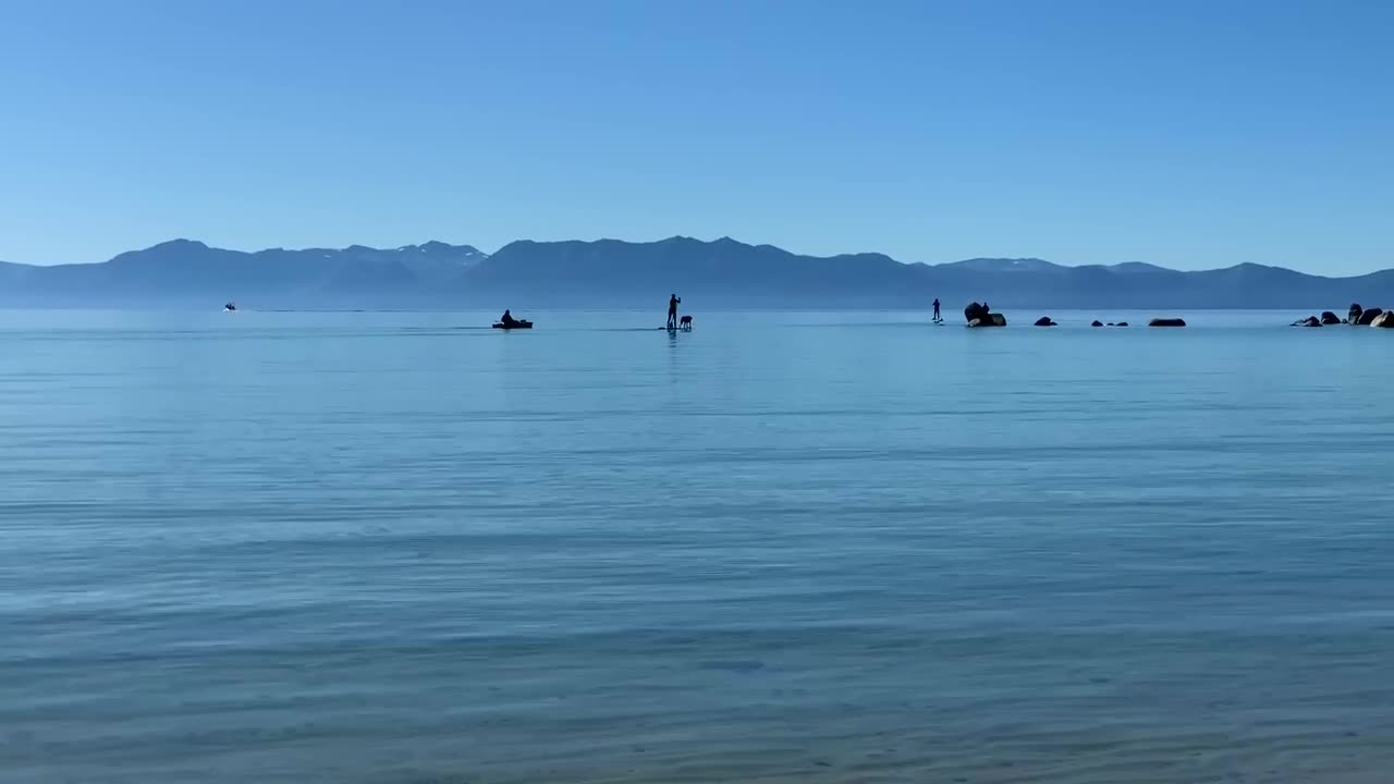 Silhouettes of people kayaking and paddle boarding at Sand Harbor State Beach in Incline Village, Nevada