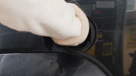 man refuels his car at a gas station 01