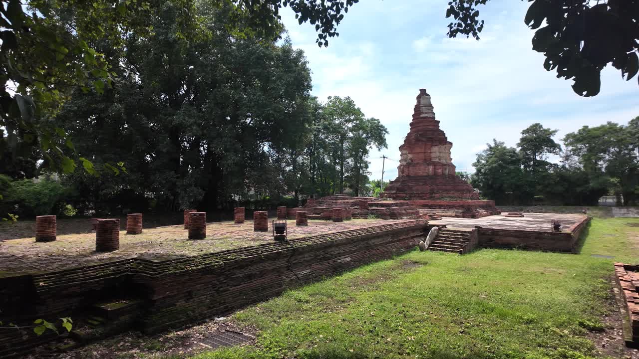 Wat E Khang temple ruins with a brick stupa and overgrown stone structures on a sunny day