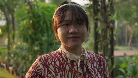 portrait of a young asian girl looking away in a garden