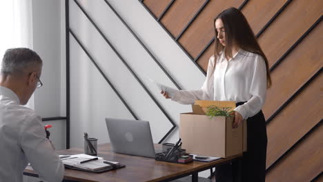 a woman is collecting her things in an office