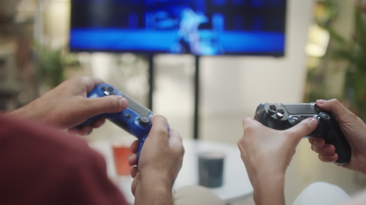 Two people playing video games with controllers in a living room