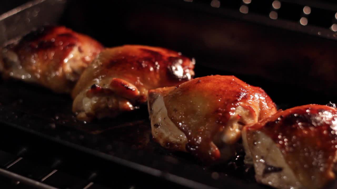 Greasy oily chicken cooking in a grill oven, closeup