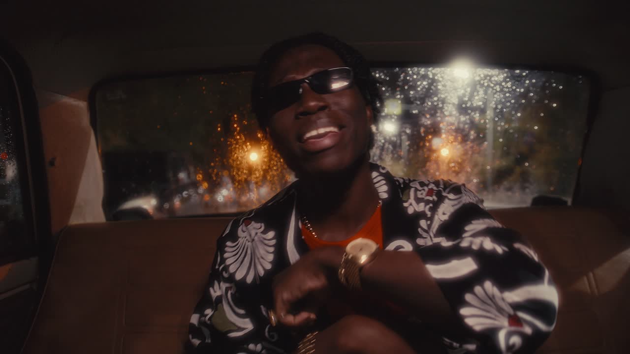 Black Rapper Riding in Car Performing Hip-Hop Song to Camera