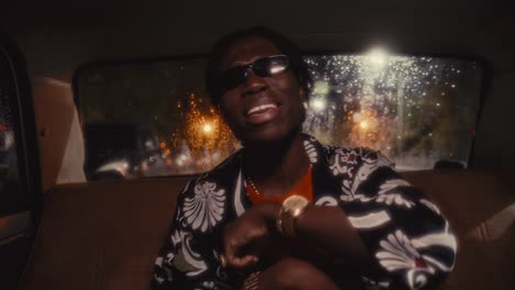 black rapper riding in car performing hip-hop song to camera