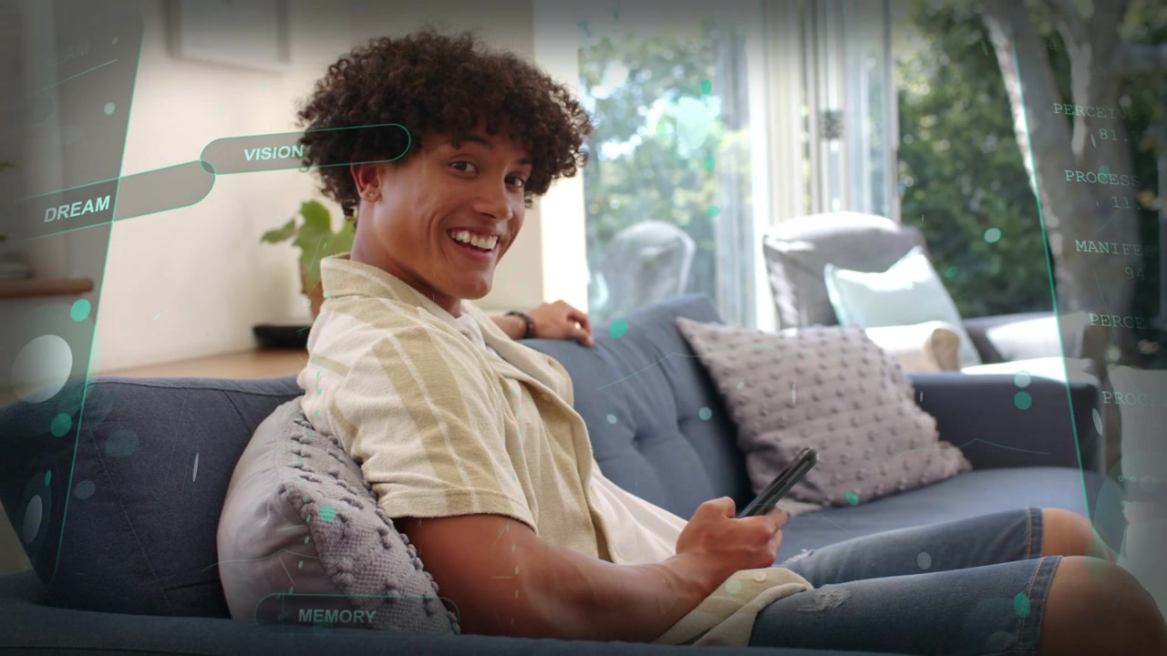 Reading phone message, man in striped shirt smiling, facing camera on blue couch with HUD labels