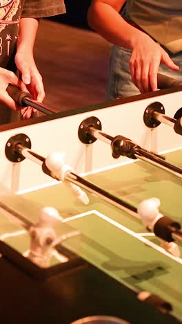 two players engaged in intense foosball match