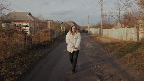 mujer caminando por un camino de campo en otoño