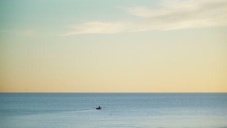 Bote-De-Remos-De-Persona-En-Aguas-Tranquilas-Y-Tranquilas-Al-Atardecer,-Fondo-Calmante