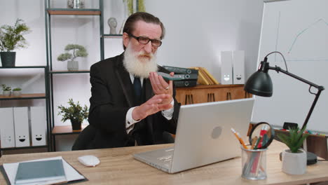 senior business man working, having mobile phone talk at office workplace using messenger chat apps