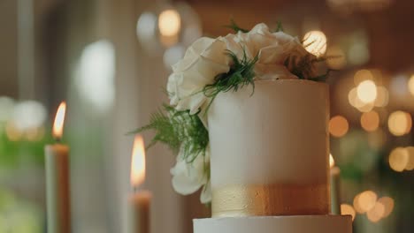 wedding cake with white roses slowly rotating by candlelight