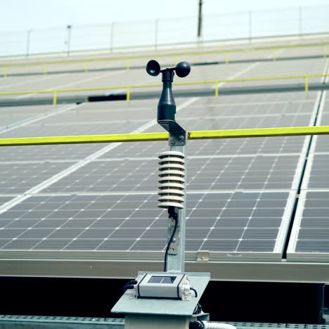 weather station for measuring wind velocity background solar cells. alternative source of electricity. solar farm.