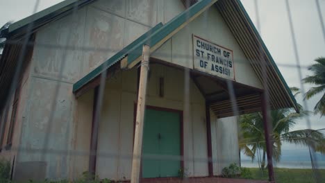 an abandoned and weathered beachside church on a gloomy day, showing the front entrance