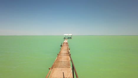 drone volando hacia la cabina a lo largo del muelle en el lago shaykhon tudakal en uzbekistán