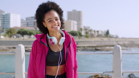 black woman, afro and headphones in beach fitness