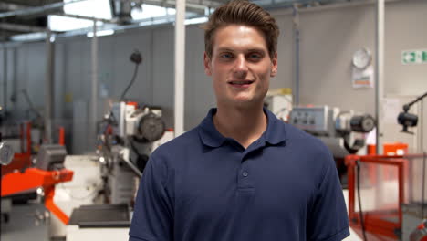 portrait of male engineer walking towards camera in workshop