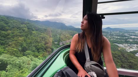 asian woman rides cable car in the wet tropics world heritage area, queensland, australia