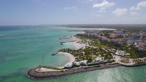 aerial view around the coast of cap cana marina of punta cana, sunny dominican republic - circling, drone shot